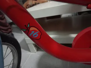 Bicicleta infantil roja con ruedines