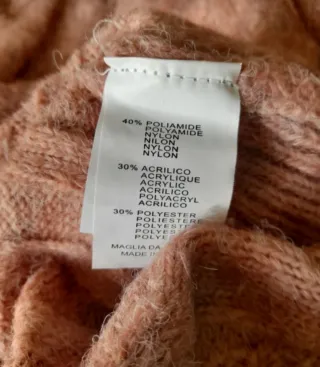 Maglione rosa lavorato a trecce