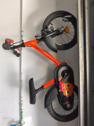 Bicicleta infantil naranja con ruedines