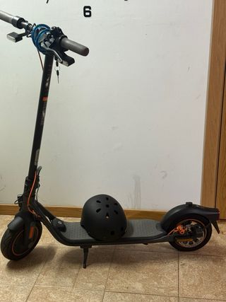 Patinete eléctrico negro con casco