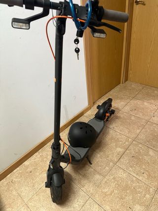 Patinete eléctrico negro con casco