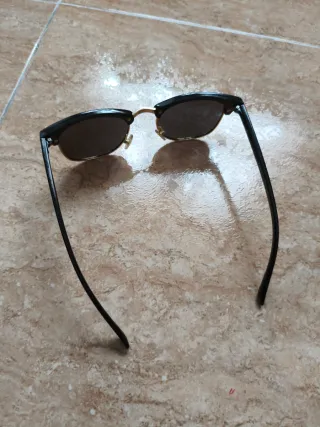 Gafas de sol negras y doradas