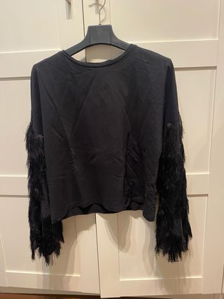 Blusa negra con mangas de flecos
