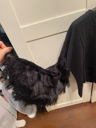 Blusa negra con mangas de flecos