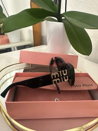 Gafas de sol Miu Miu negras y doradas