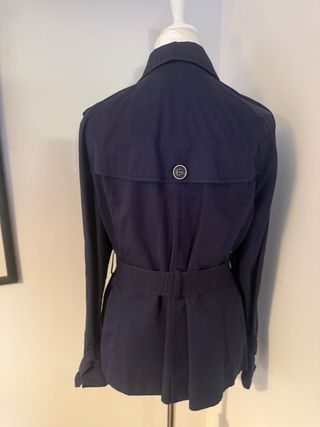 Chaqueta gabardina azul con cinturones.