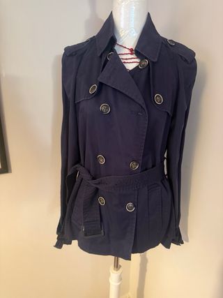 Chaqueta gabardina azul con cinturones.