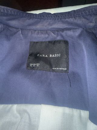 Chaqueta gabardina azul con cinturones.