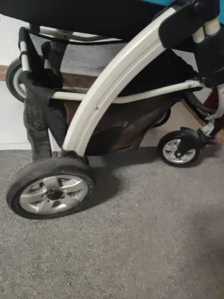 Carrito de bebé azul con saco y plástico