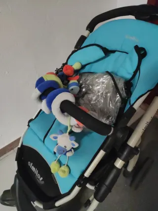 Carrito de bebé azul con saco y plástico