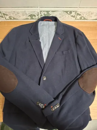 Americana azul marino, con coderas en marrón.