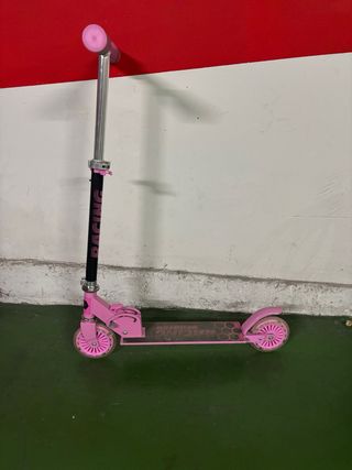 Patinete infantil plegable rosa con luces.