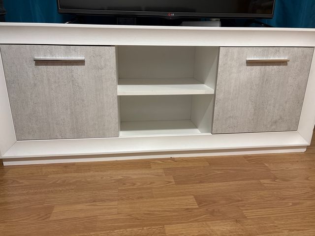 Mueble TV blanco y gris con puertas.