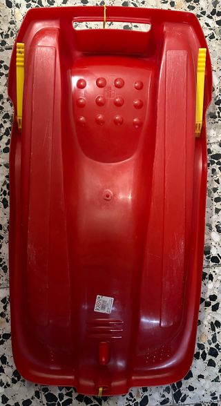 Trineo rojo con cuerda y asas amarillas