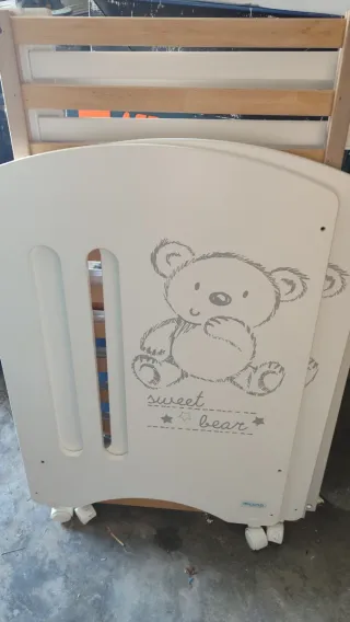 Cuna de bebé con osito y ruedas