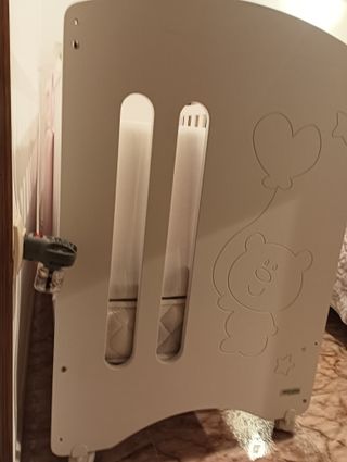 Cuna infantil blanca con protector rosa