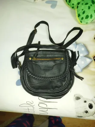 Bolso negro bandolera con trenzado.
