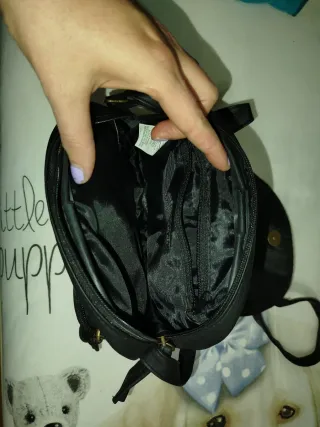 Bolso negro bandolera con trenzado.