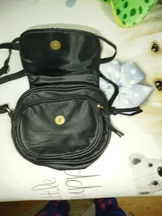 Bolso negro bandolera con trenzado.