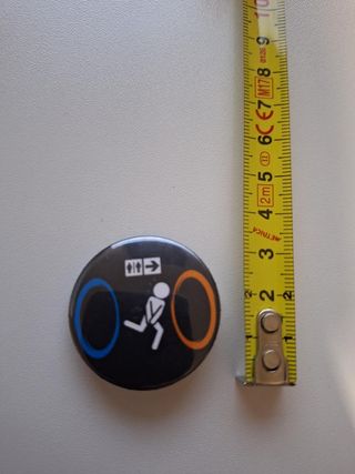 Spilla Portal Nera con Portali Blu e Arancioni