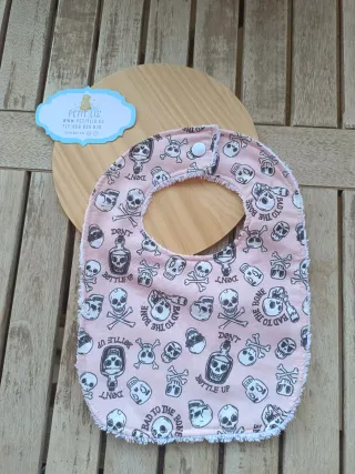 Babero infantil con calaveras rosa