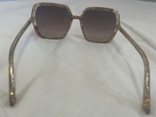 Gafas de sol doradas y marrones con su caja