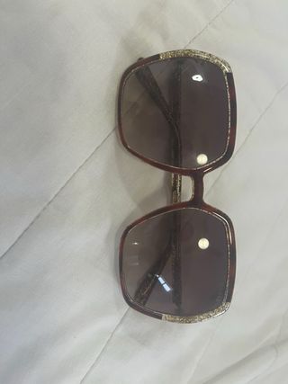 Gafas de sol doradas y marrones con su caja