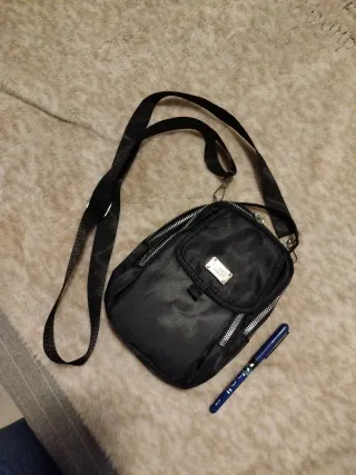 Mochila negra pequeña bandolera.