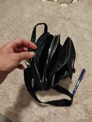 Mochila negra pequeña bandolera.