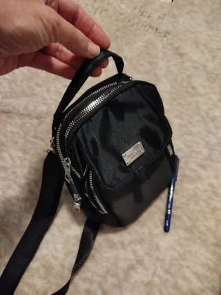 Mochila negra pequeña bandolera.