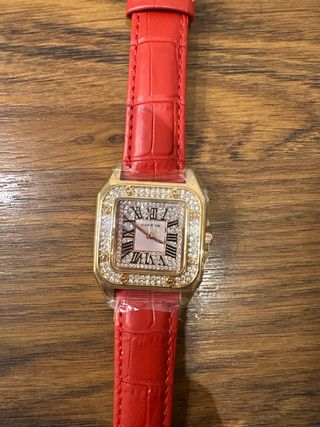 Reloj dorado con correa roja