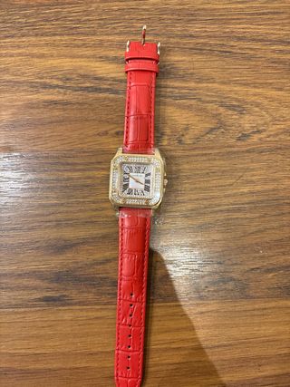 Reloj dorado con correa roja