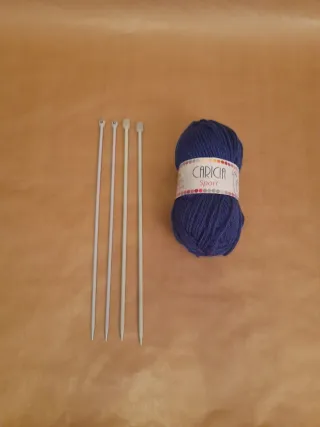 4 agujas de tejer y ovillo azul.