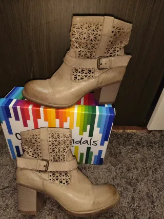 Botas camperas de piel con detalles calados.