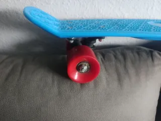 Patinete monopatín azul con ruedas rojas
