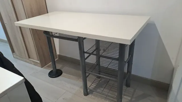 Mesa blanca con estanterías metálicas