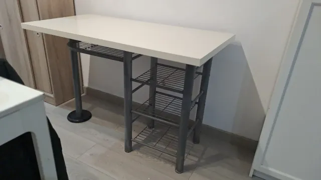 Mesa blanca con estanterías metálicas