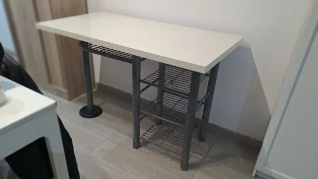 Mesa blanca con estanterías metálicas