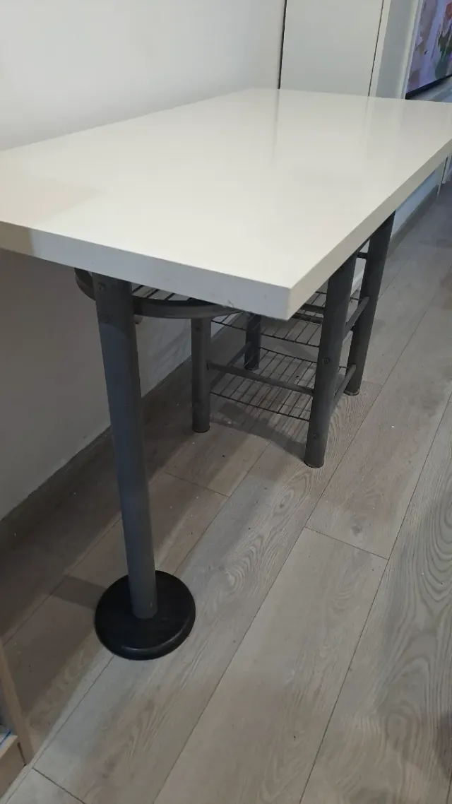 Mesa blanca con estanterías metálicas