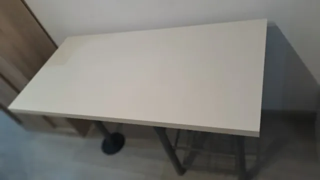 Mesa blanca con estanterías metálicas