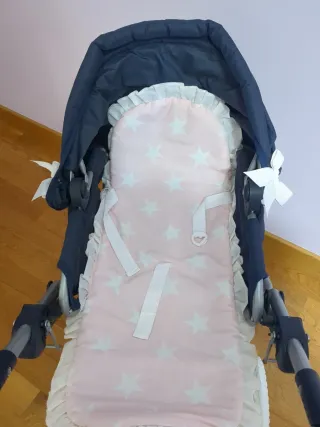 Carrito de bebé azul con capazo rosa