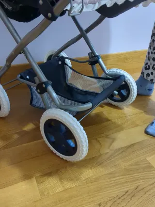 Carrito de bebé azul con capazo rosa