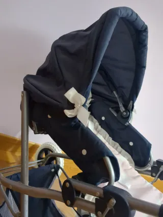 Carrito de bebé azul con capazo rosa