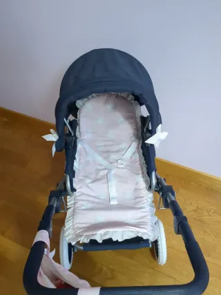 Carrito de bebé azul con capazo rosa