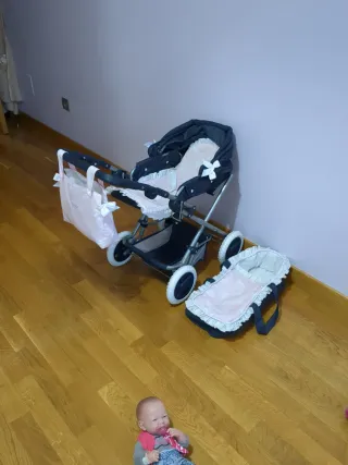 Carrito de bebé azul con capazo rosa