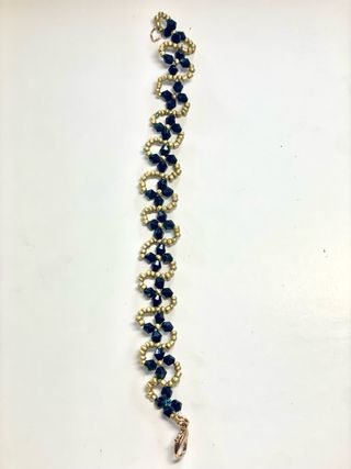 Pulsera artesanal flor negra detalles dorados