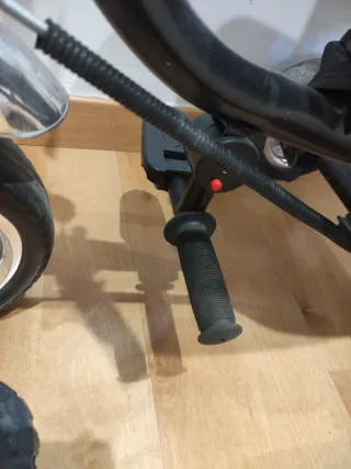 Triciclo infantil con capota y manillar.