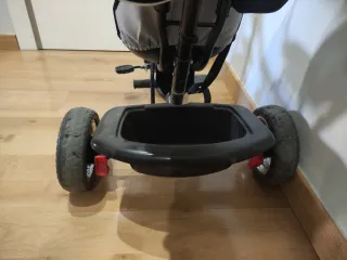 Triciclo infantil con capota y manillar.