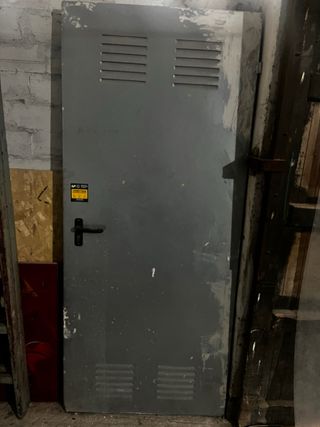 Puerta metálica gris con ventilación