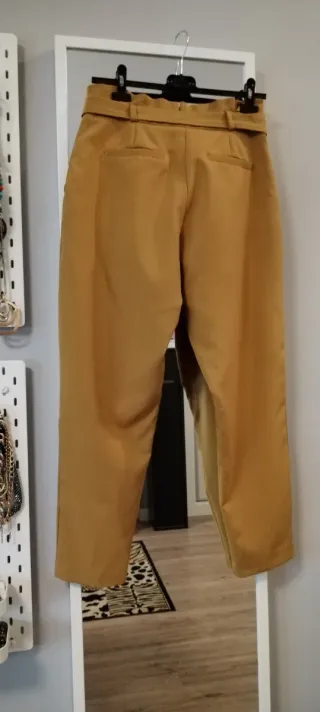 Pantalón de traje color mostaza con cinturón.